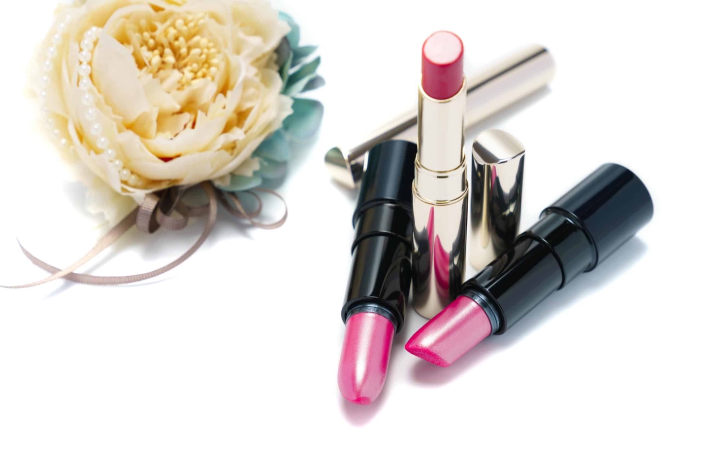 Lippenstifte, Perlenkette und eine Blüte — Stillleben aus dem Bildbestand von KOSMEGI